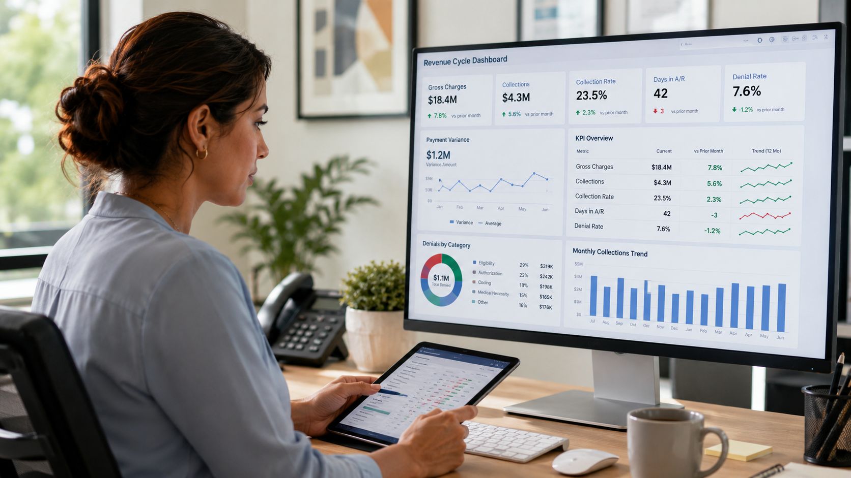 A professional revenue cycle specialist analyzing financial data on a large computer monitor and tablet at work.